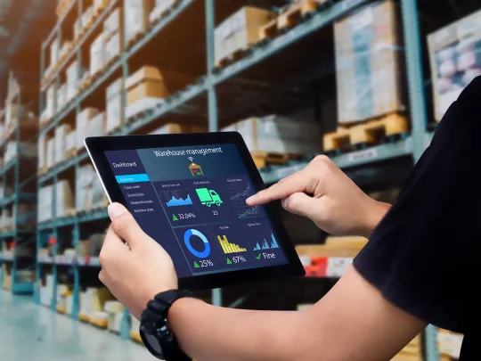 A worker in a factory creates invoies using Boubyan's Smart Supply Chain Finance Solutions.