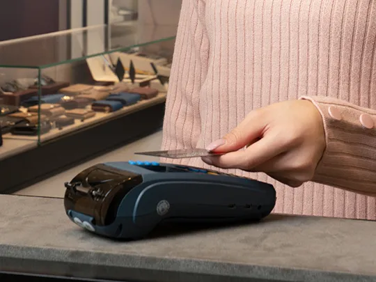 A Boubyan corporate customer making a payment with a card at a POS machine.