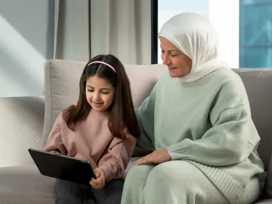 Mother educating about the benefits of Boubyan's Al Ghaly children's account with her daughter.