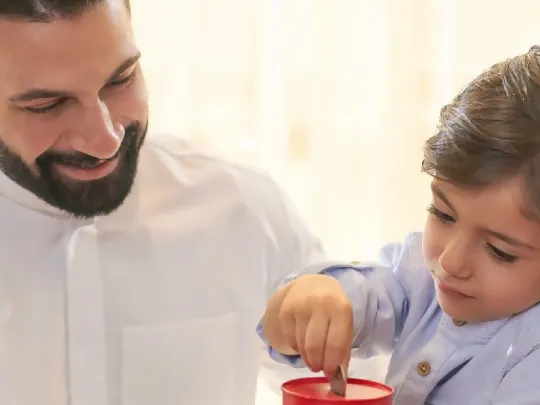 A Boubyan customer with his son after creation of Boubyan Bank’s Wakala deposit account
