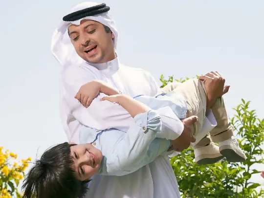 A Boubyan customer's happy moment with his son after creation of Boubyan Bank’s Al Mona deposit account