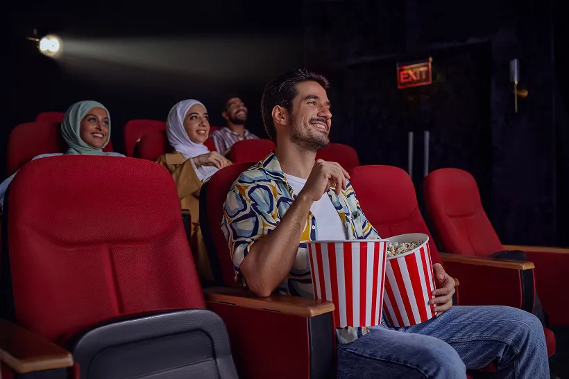 Group of People Watching Cinema Using Cashback Rewards