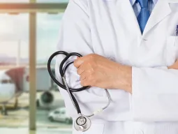 Travel medical insurance is shown by a doctor holding a stethoscope