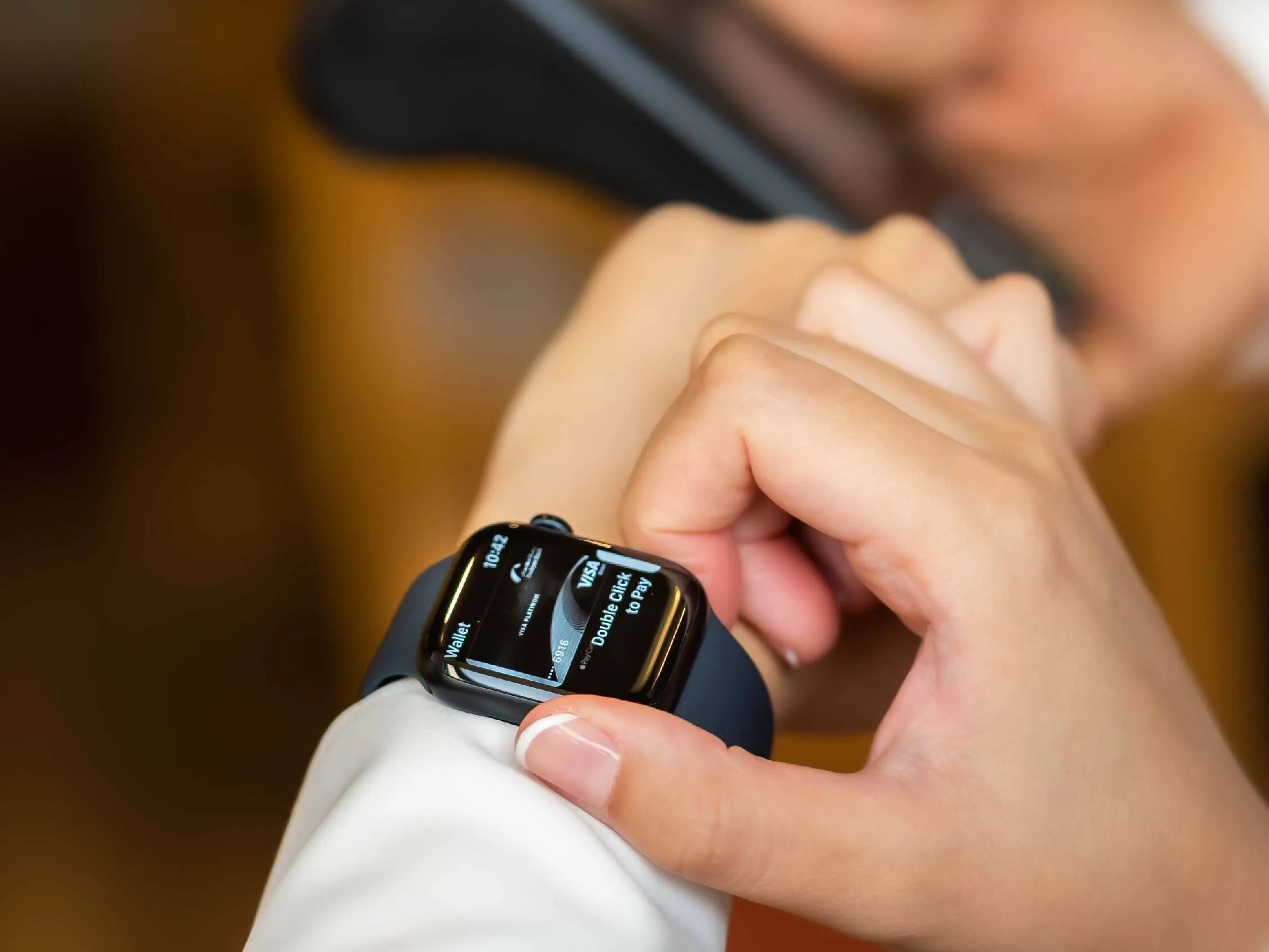 A person accessing a digital wallet to pay cashlessly via a smartwatch