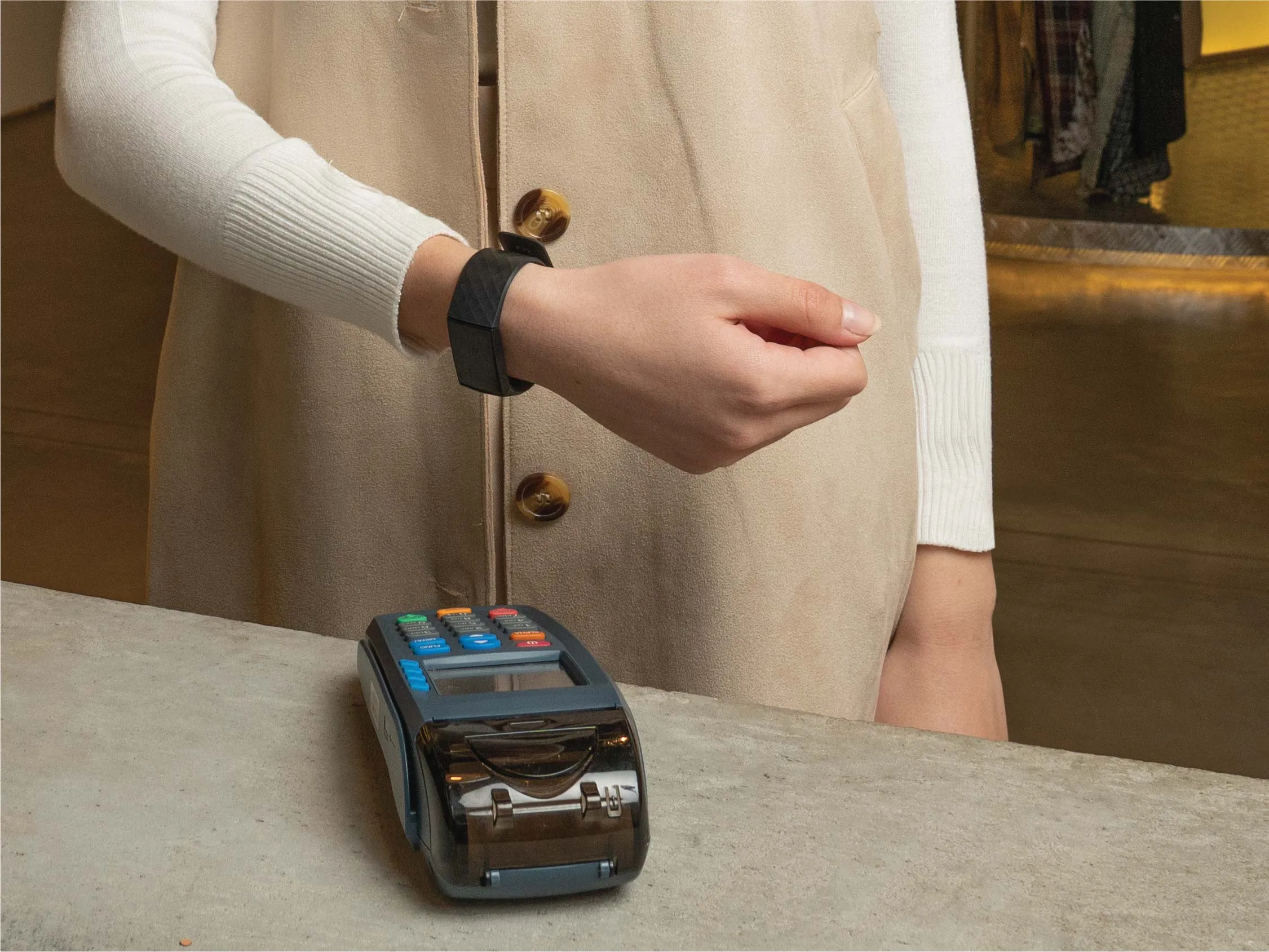 امرأة كويتية تستخدم خدمات Utap بتقنية التواصل قريب المدى NFC على جهاز نقاط البيع من خلال الساعة الذكية