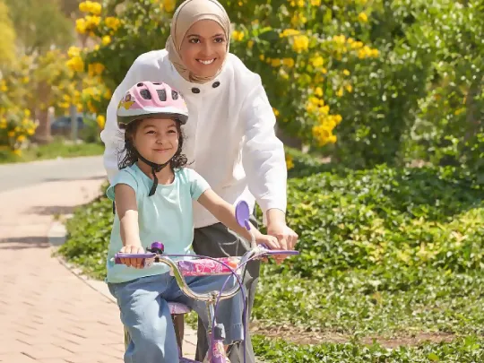 أم تعلم ابنتها كيفية ركوب الدراجة