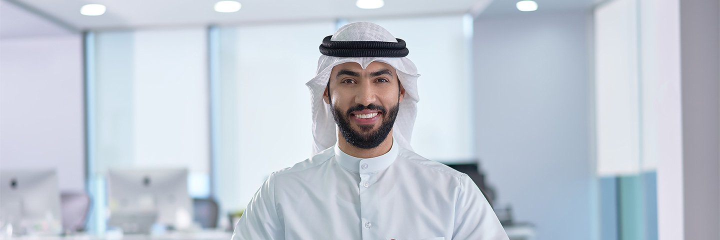 Happy boubyan staff welcoming new customers - موظف بنك بوبيان يبتسم للعملاء الجدد