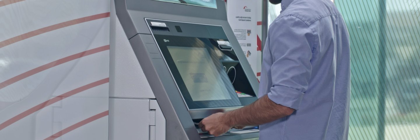 A customer withdrawing money from a Boubyan Bank ATM
