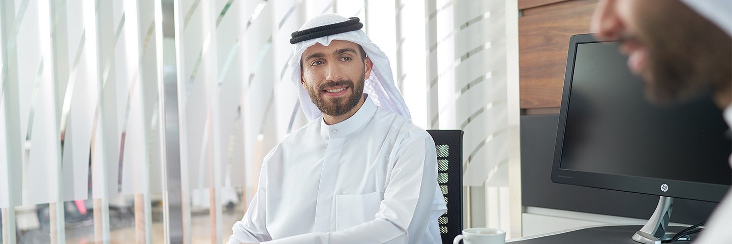 Customer smiles to boubyan staff when he is opening his account in the branch - عميل بوبيان يبتسم لموظف بوبيان عند فتح حسابه في الفرع